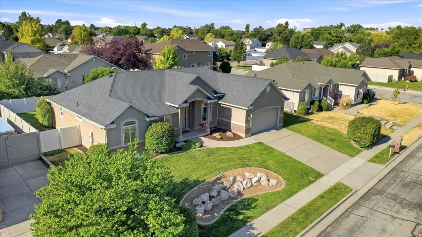 Single-story residential structure featuring a gray shingle roof, stucco and brick veneer exterior, and an attached two-car garage