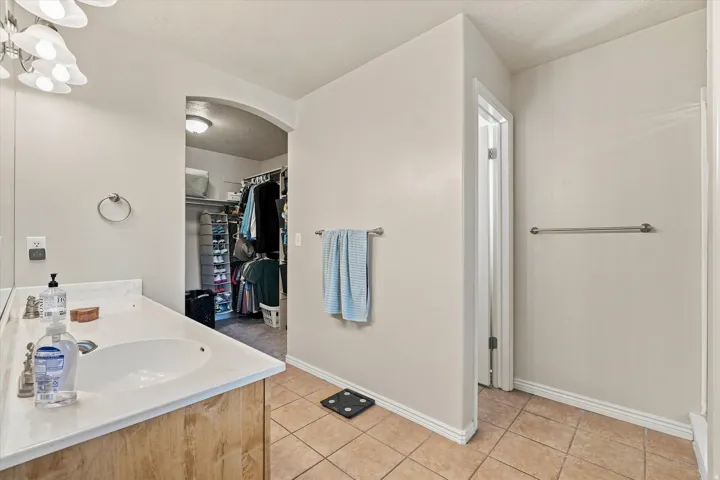 Vanity with white countertop, integrated sink, and wood-finish cabinetry