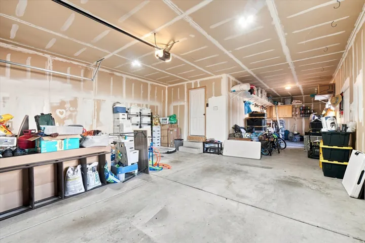 Attached garage featuring a concrete floor and exposed drywall
