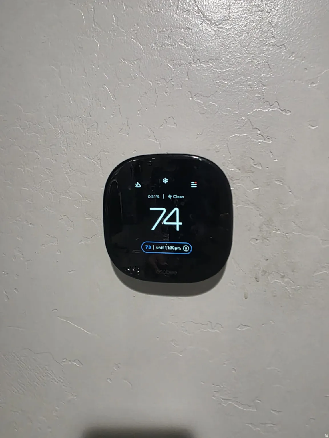 Ecobee smart thermostat on a textured wall