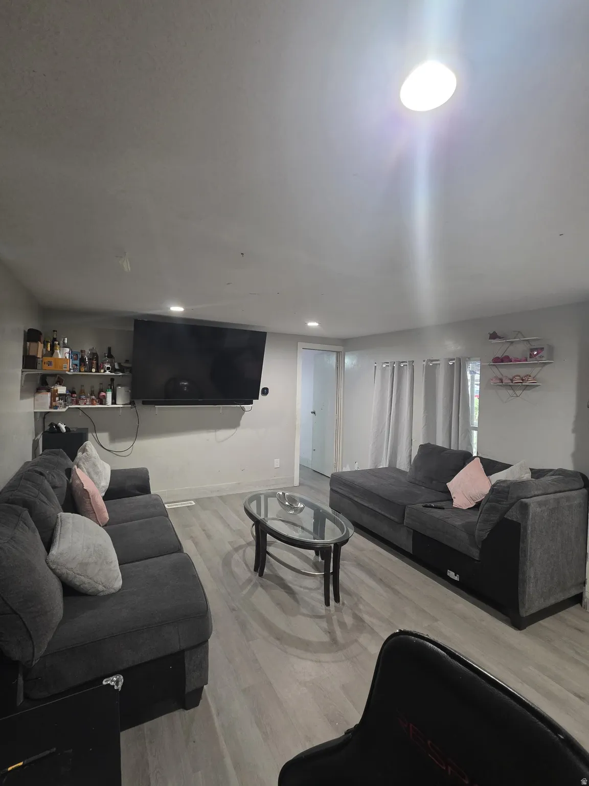Recessed lighting, wood-finish flooring, and a built-in wall shelf