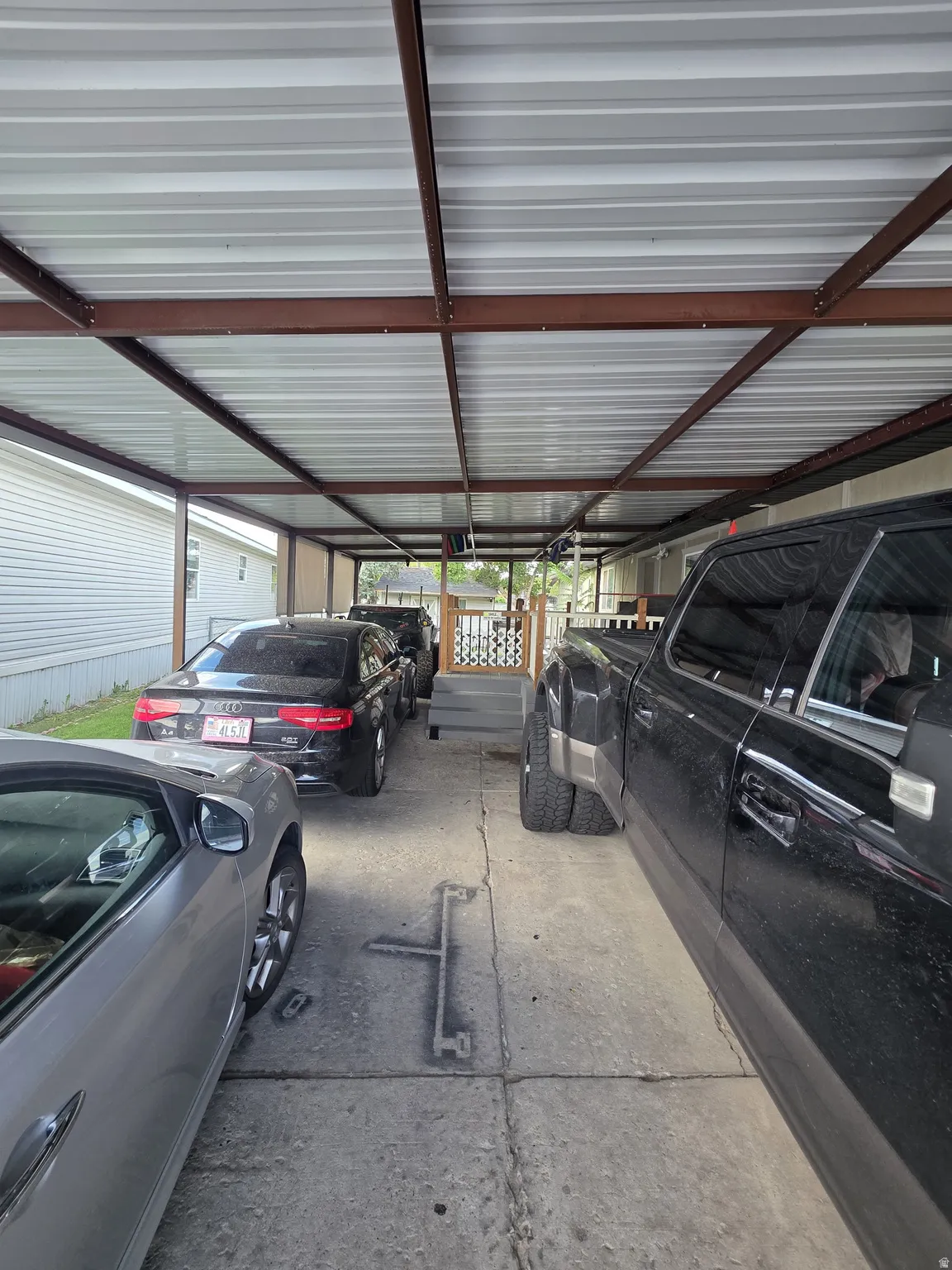 Covered parking structure with a metal roof and exposed metal beams