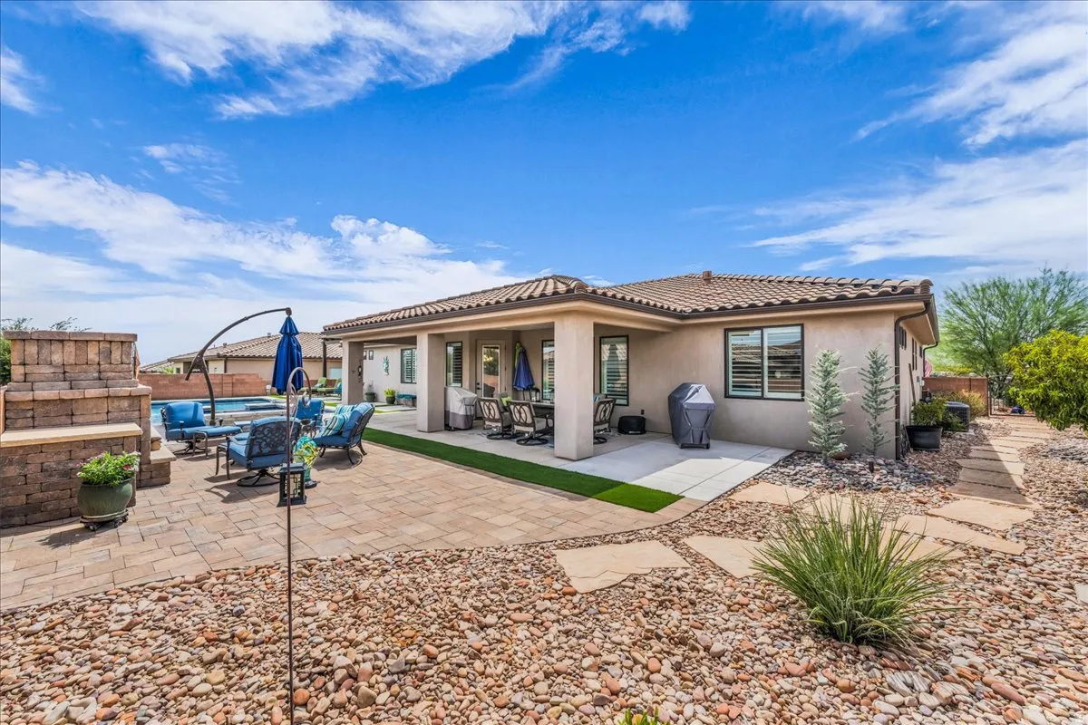 Terracotta tile roof, stucco exterior, paver patio, integrated pool, and desert landscaping