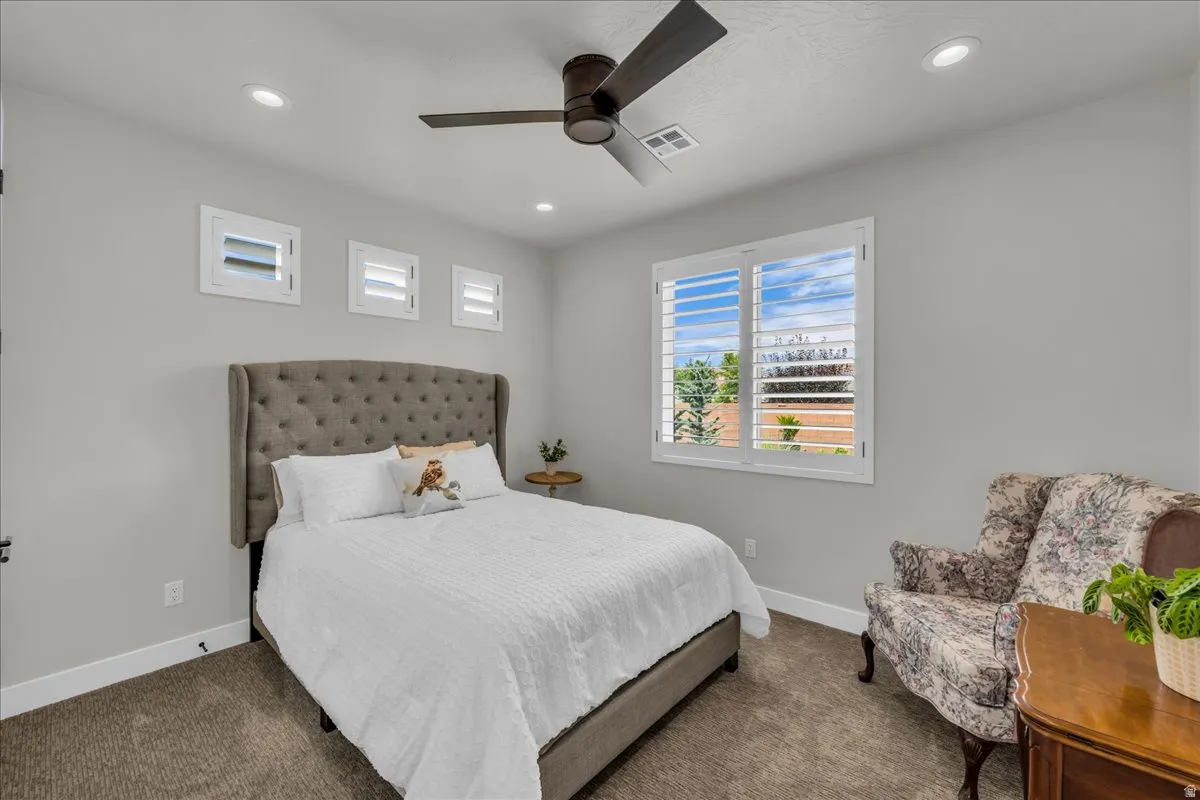 Recessed lighting, wood-finish ceiling fan, window with plantation shutters, additional transom windows, and neutral wall paint