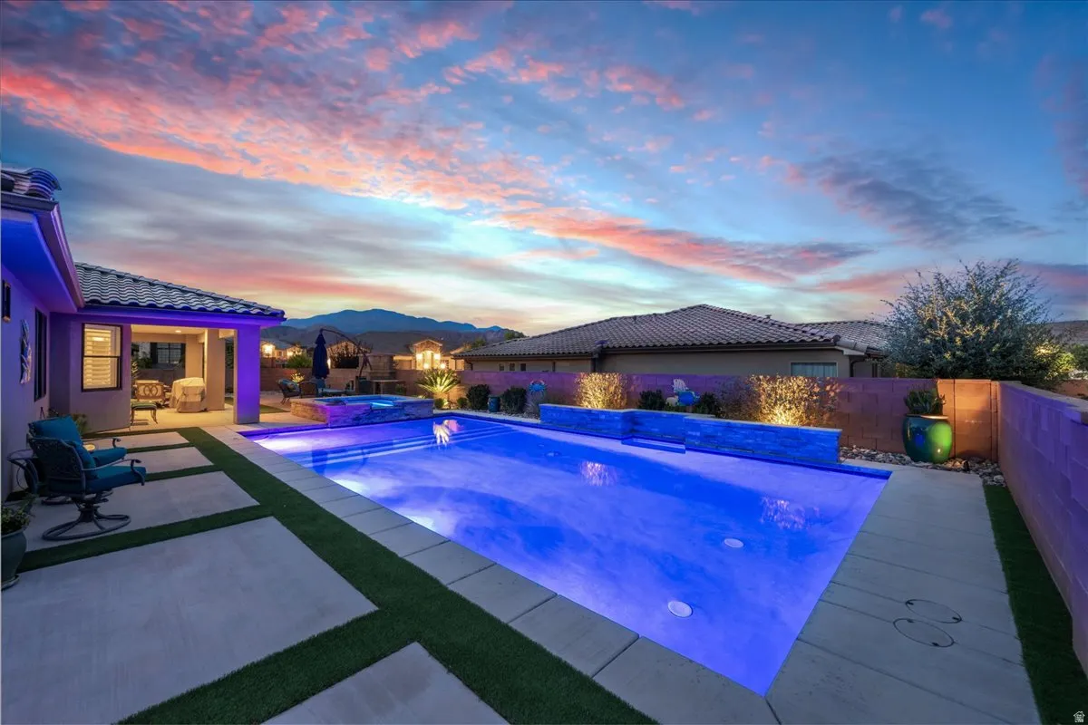 Rectangular swimming pool with integrated spa and blue lighting