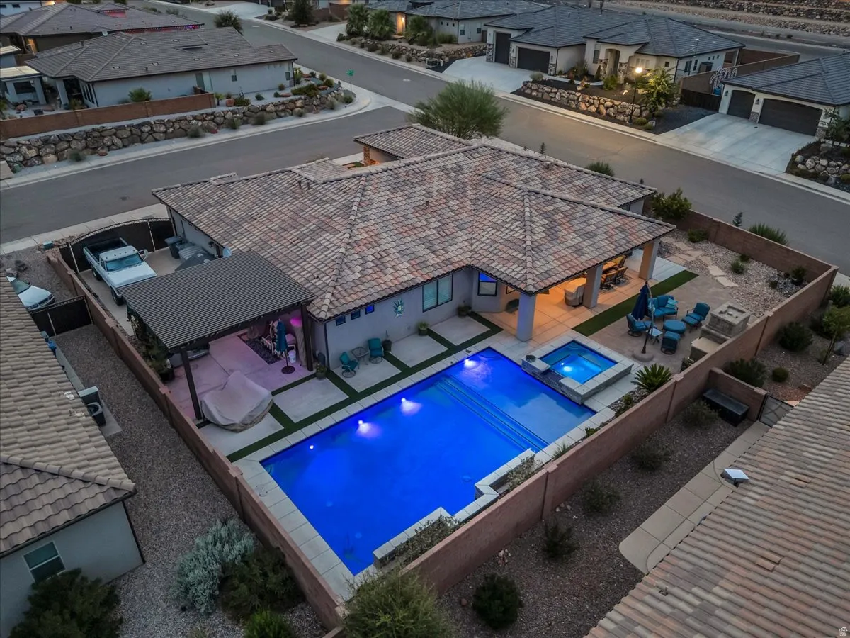 Backyard oasis featuring a swimming pool, integrated spa, covered patio, and additional pergola-covered outdoor space