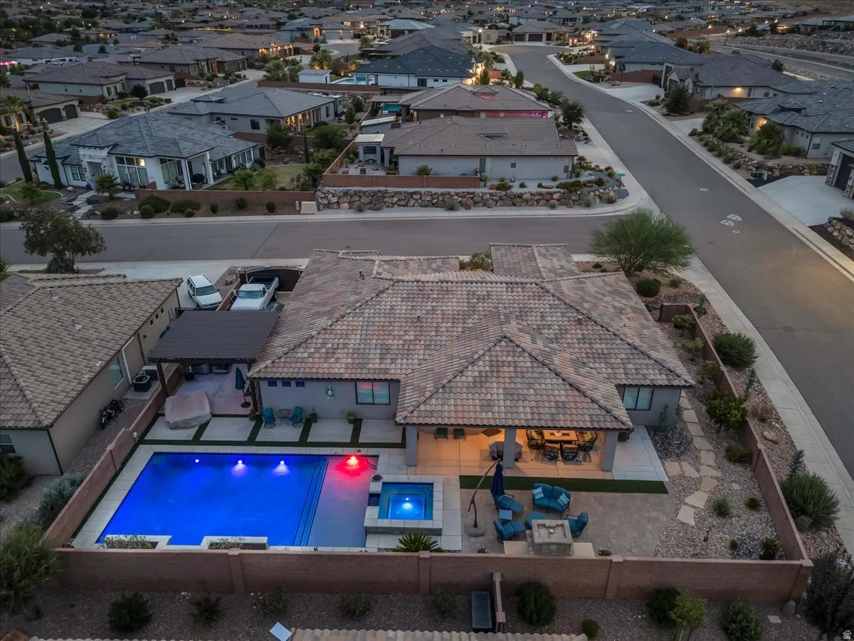 Private backyard oasis featuring a swimming pool, integrated hot tub, covered patio, and fire pit