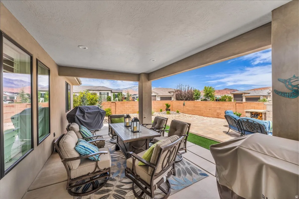 Covered patio featuring recessed lighting, a concrete floor, and direct access to a landscaped yard with artificial turf and paver stones
