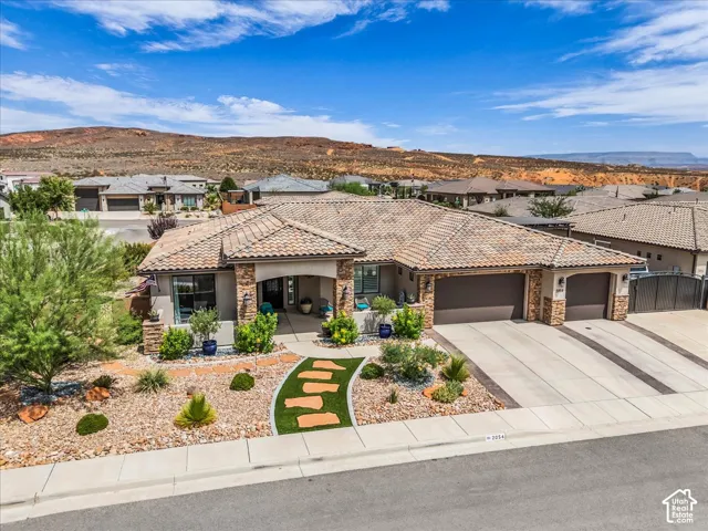 Single-story residence featuring a tile roof, stone accents, and an attached three-car garage