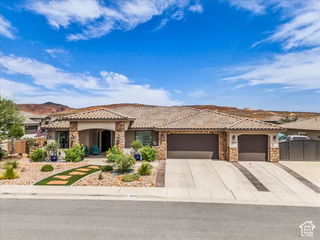 Mediterranean-style architecture with a tile roof, stone accents, and an arched entry