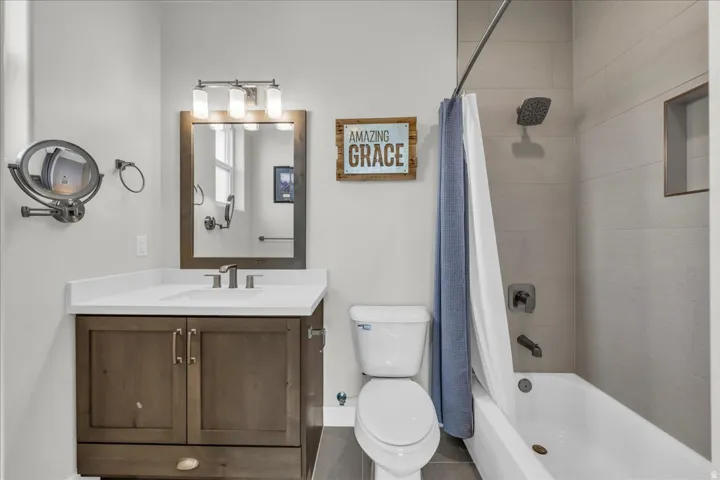 Vanity with white countertop, undermount sink, and dark wood-finish cabinetry