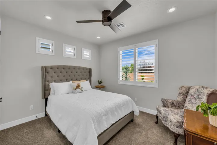 Recessed lighting, wood-finish ceiling fan, window with plantation shutters, additional transom windows, and neutral wall paint
