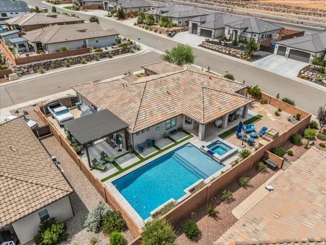 Exterior featuring a tiled roof, in-ground swimming pool, integrated spa, covered patio, and fenced backyard