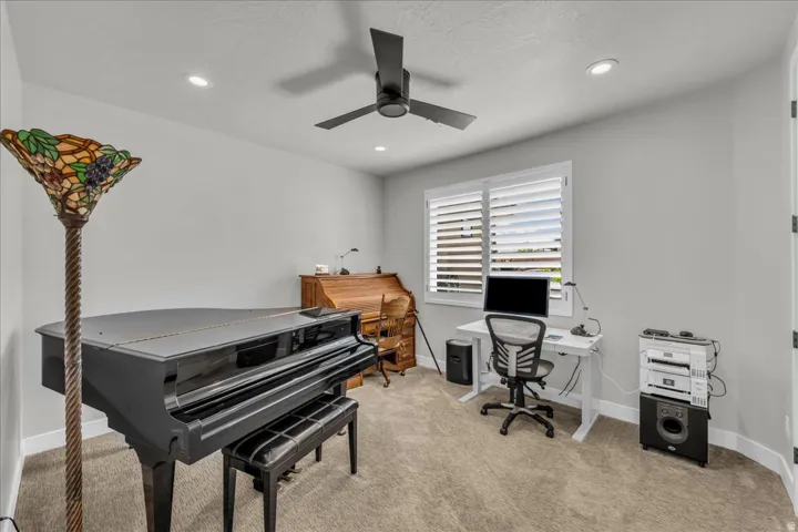 Recessed lighting, ceiling fan, window with plantation shutters, light gray wall paint, and carpeted flooring