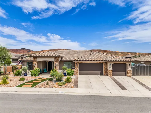 Mediterranean-style architecture with a tile roof, stone accents, and an arched entry