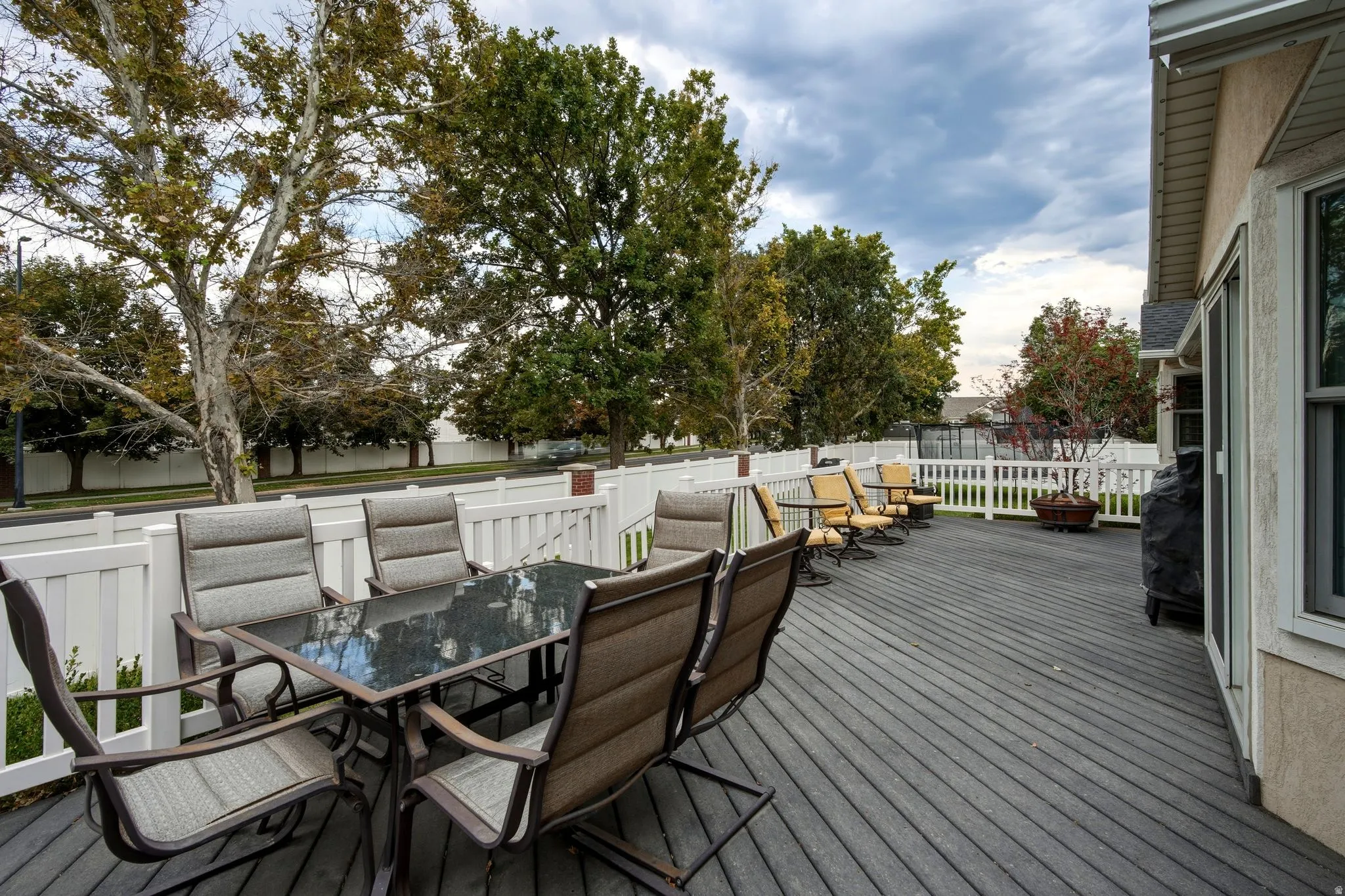 Expansive composite deck with composite decking and white railings, featuring multiple dining and lounge zones with built-in seating areas