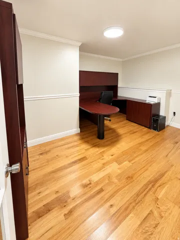 Wood-finish flooring throughout, crown molding, and chair rail detailing