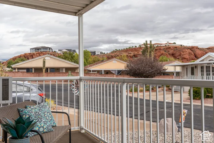 Covered porch with white metal railings and expansive red rock mountain backdrop