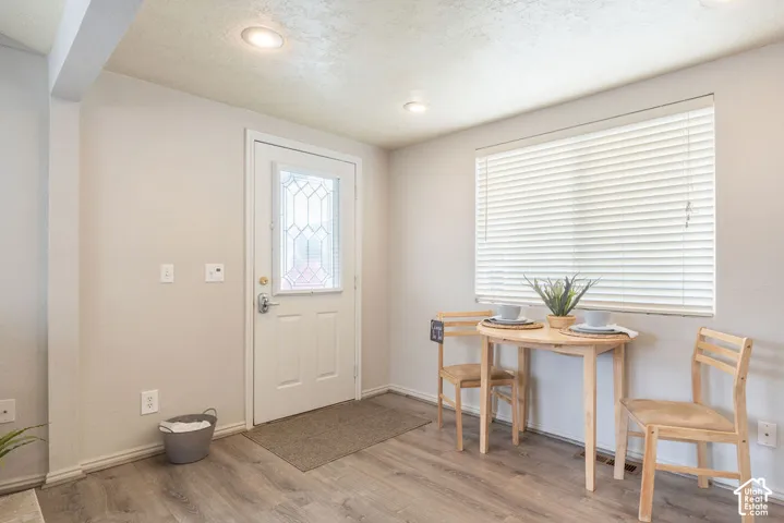 Entryway featuring wood-finish flooring, recessed lighting, and a white exterior door with an inset decorative glass panel