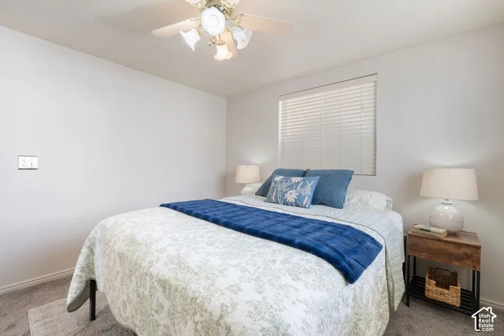 Neutral wall tones, ceiling fan with integrated lighting, and window blinds