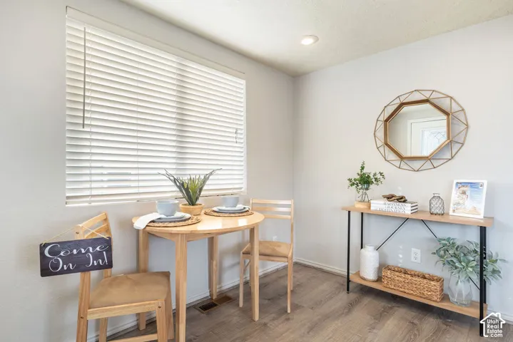 Wood-finish flooring, neutral wall tones, recessed ceiling lighting, and horizontal window blinds