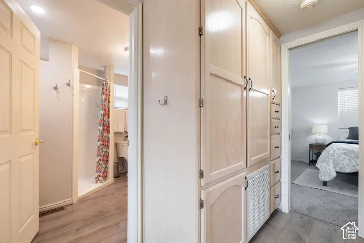 Built-in floor-to-ceiling cabinetry featuring multi-drawer storage, wood-finish flooring, and wall-mounted hardware