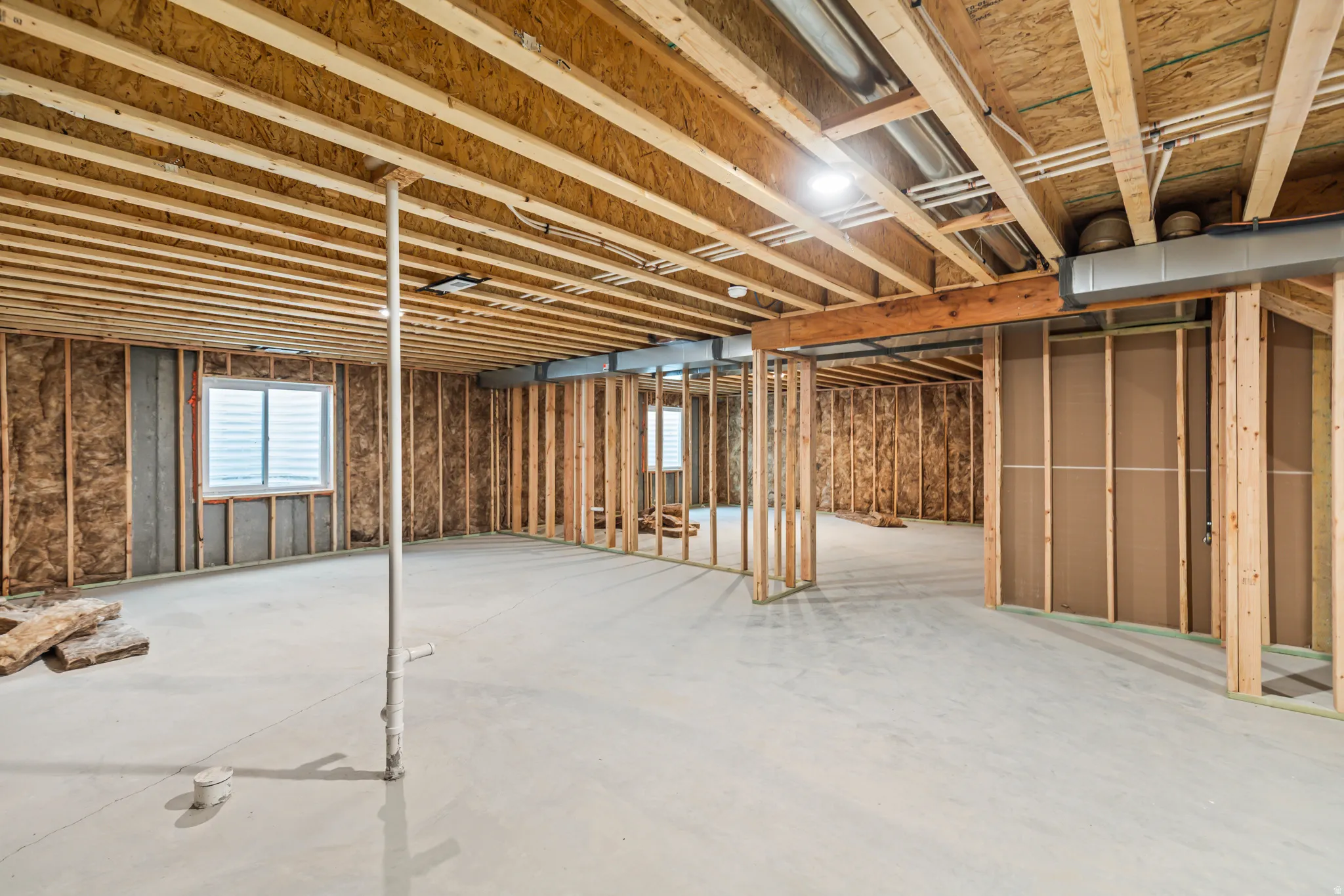 Unfinished basement with concrete flooring and exposed ceiling joists