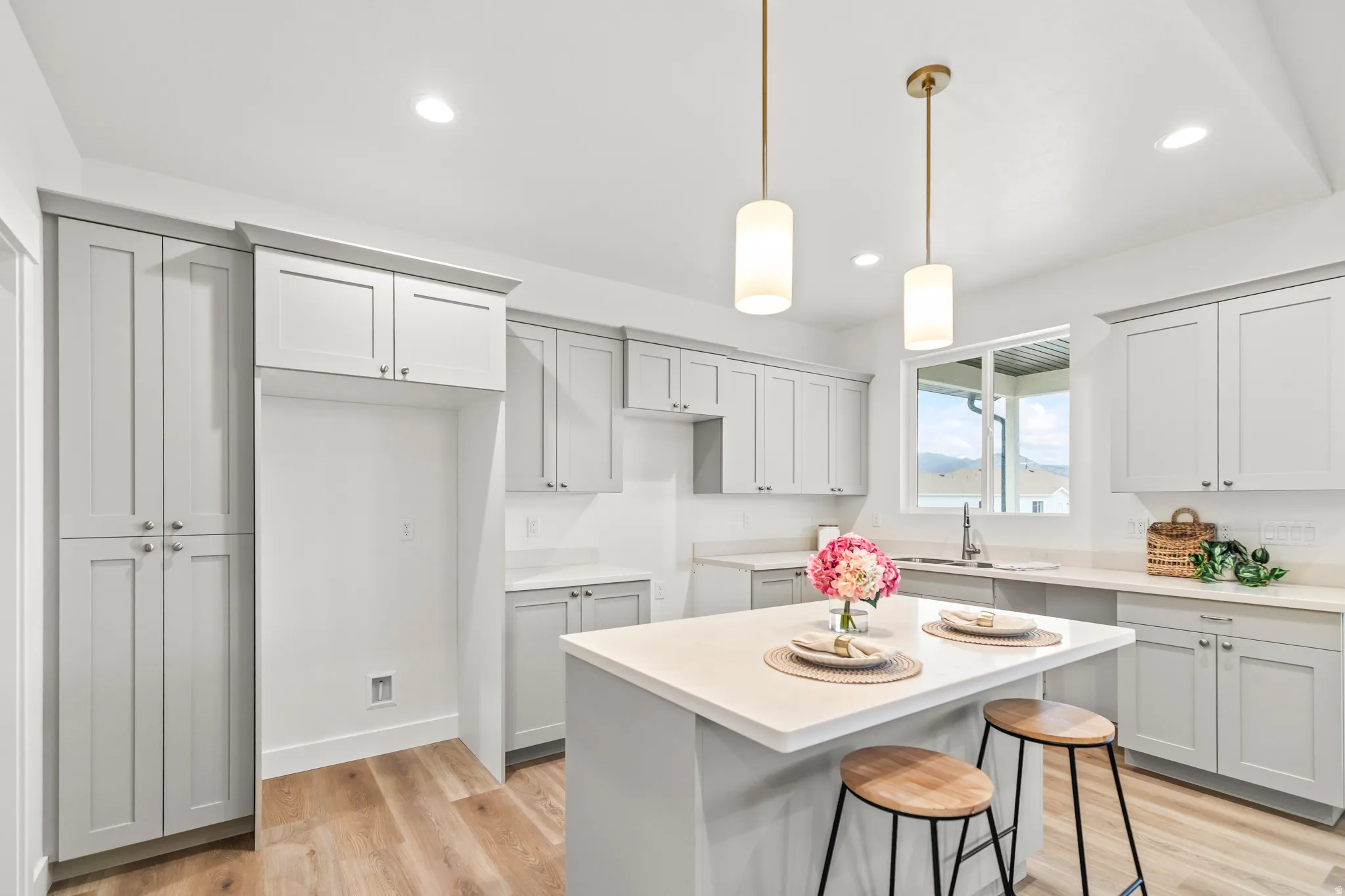 Kitchen featuring light gray shaker cabinetry, wood-finish flooring, recessed lighting, and a white countertop island
