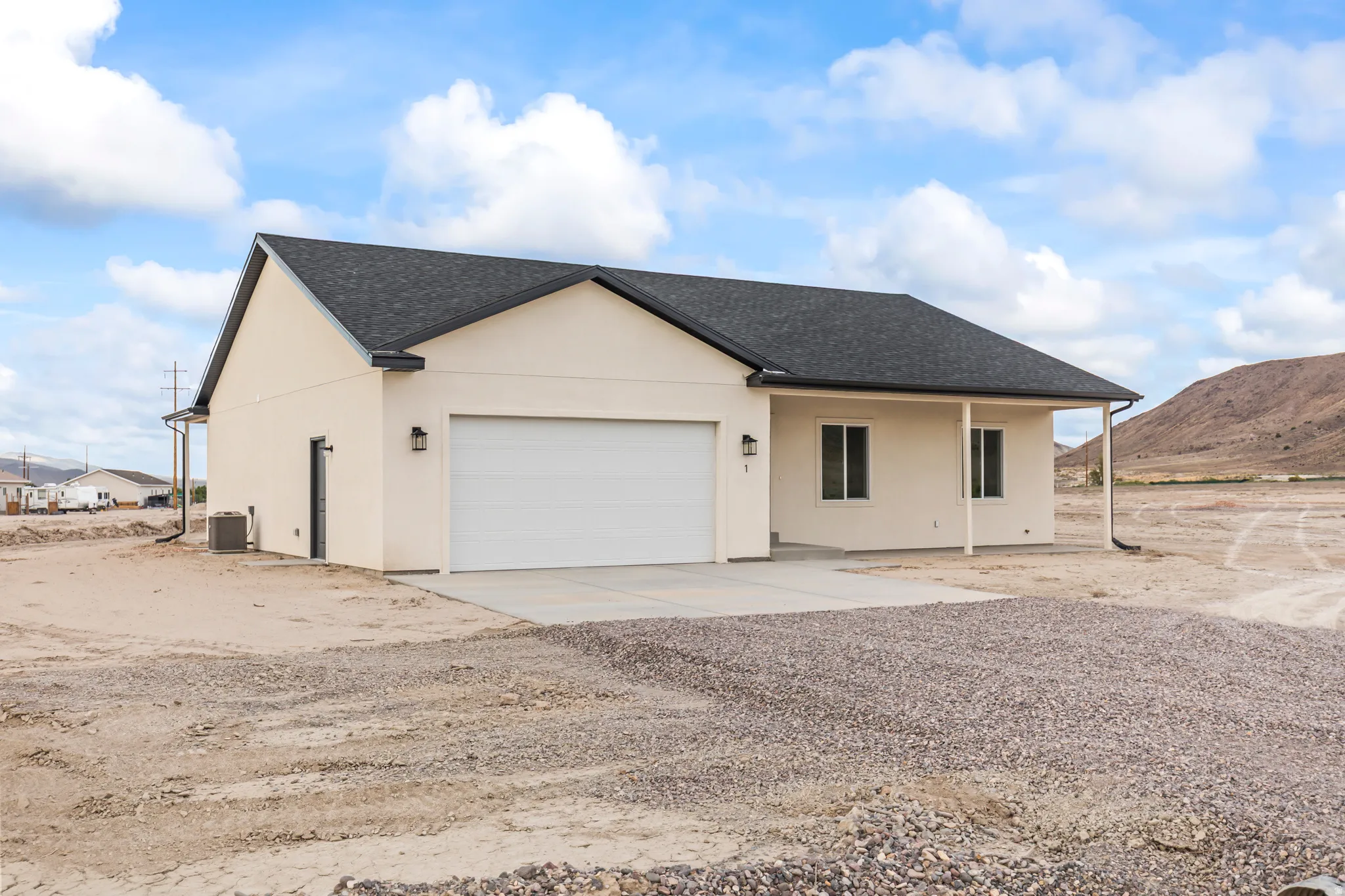 Single-story stucco exterior with a dark shingle roof, attached garage with white door, and a covered front entry
