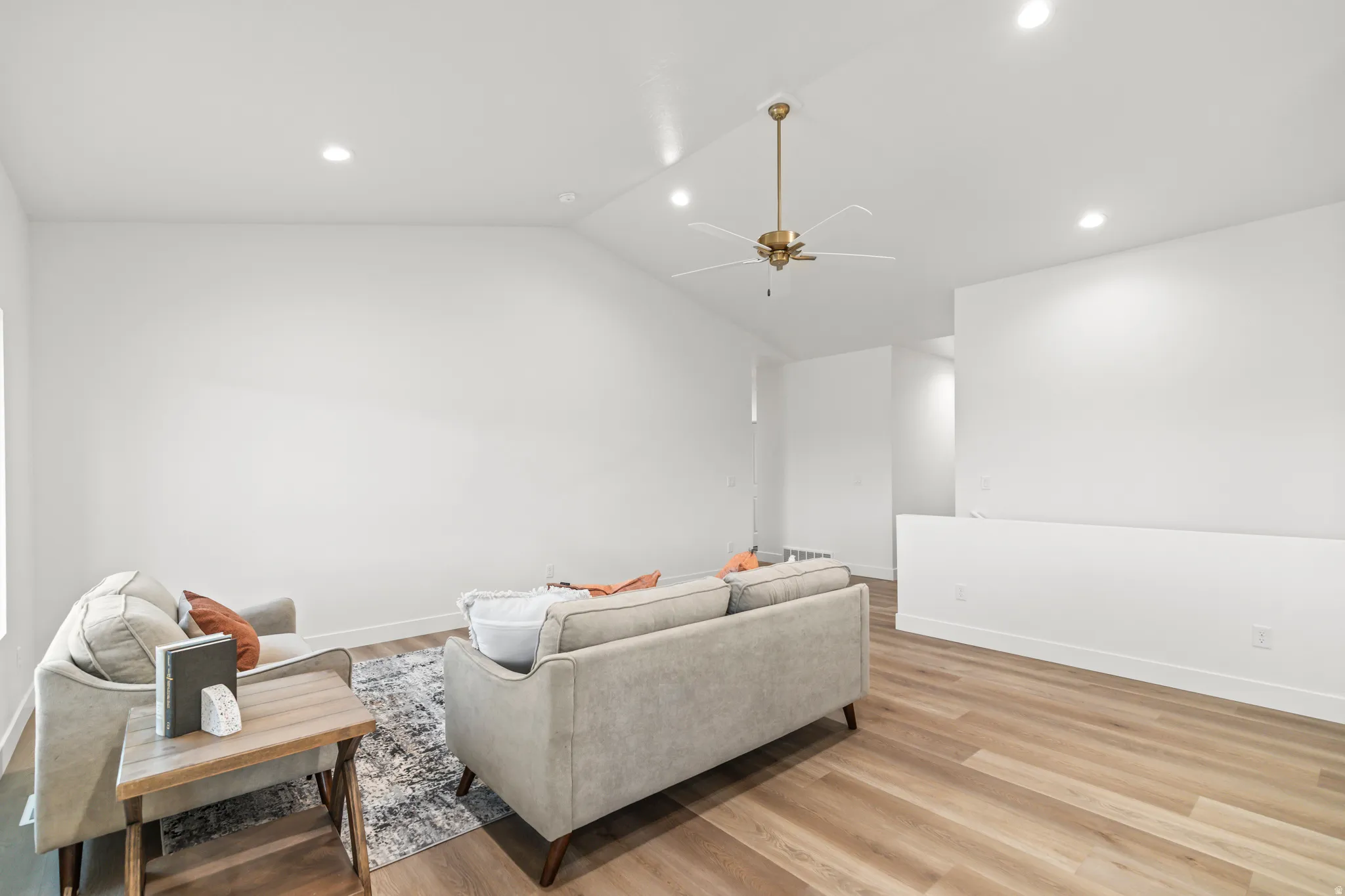 Vaulted ceiling with recessed lighting and a brass-finish ceiling fan