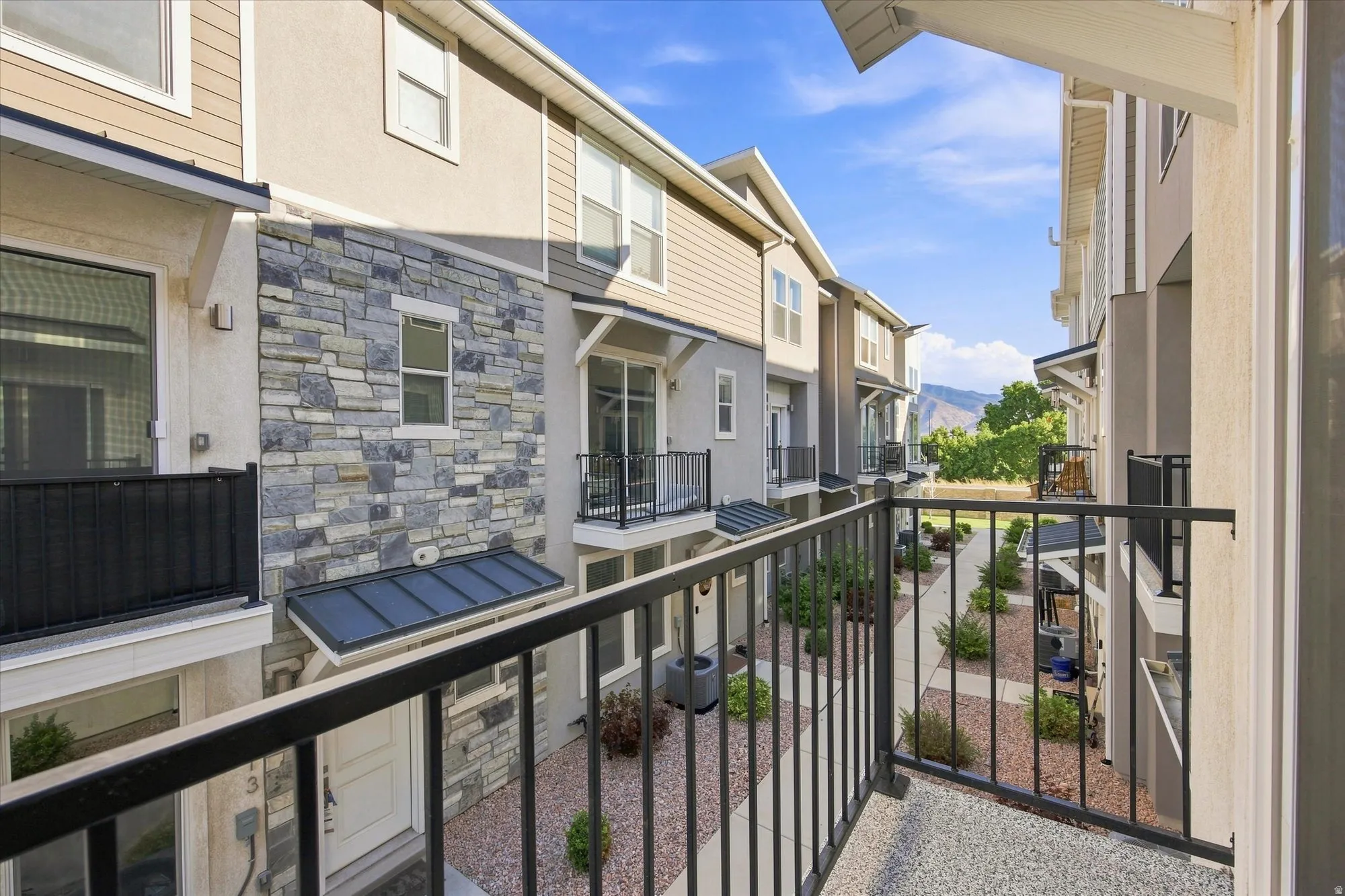 Balcony off the front, featuring a black metal railing and textured flooring.