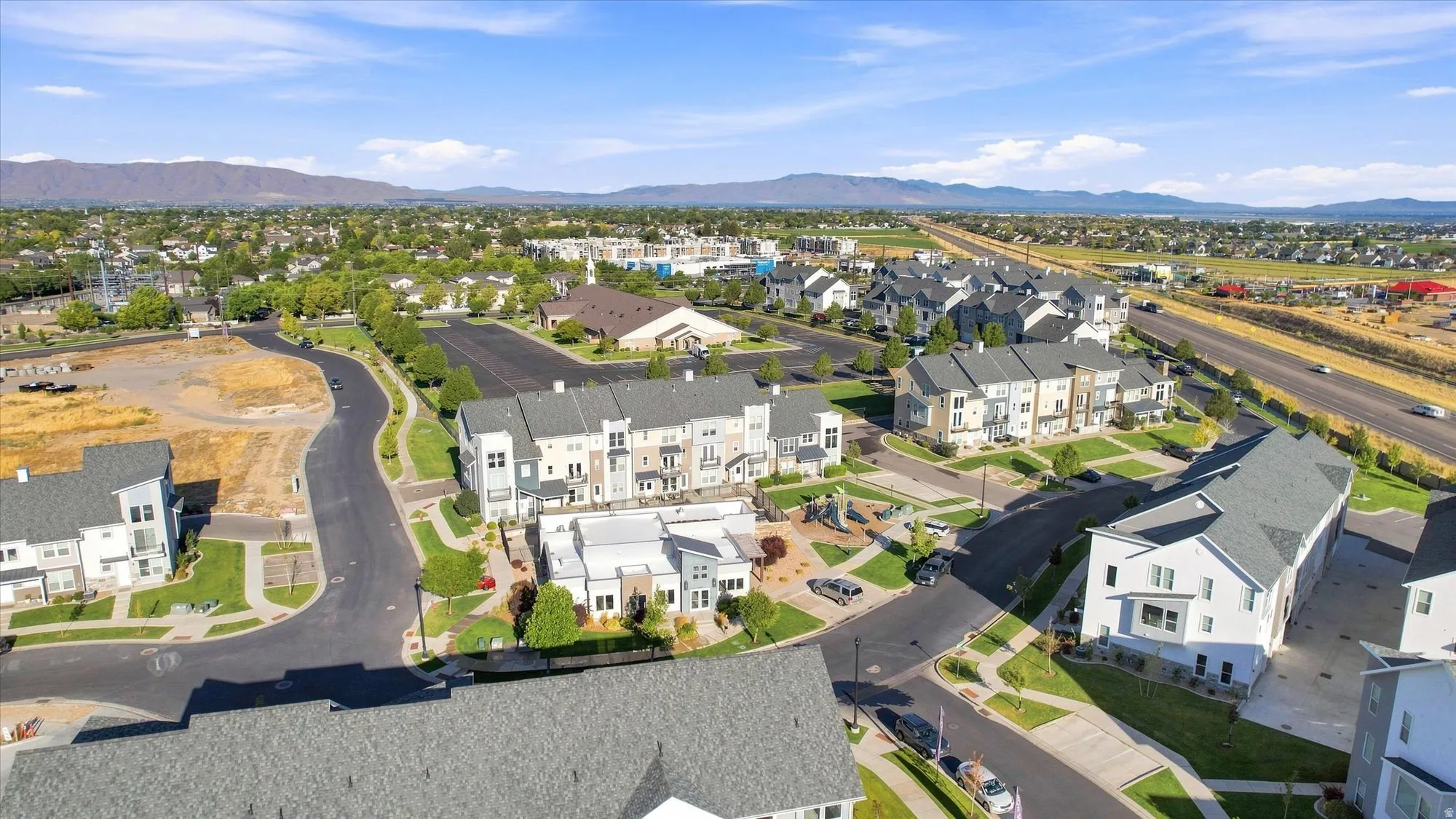 Aerial perspective of a developed residential community with townhomes and detached properties