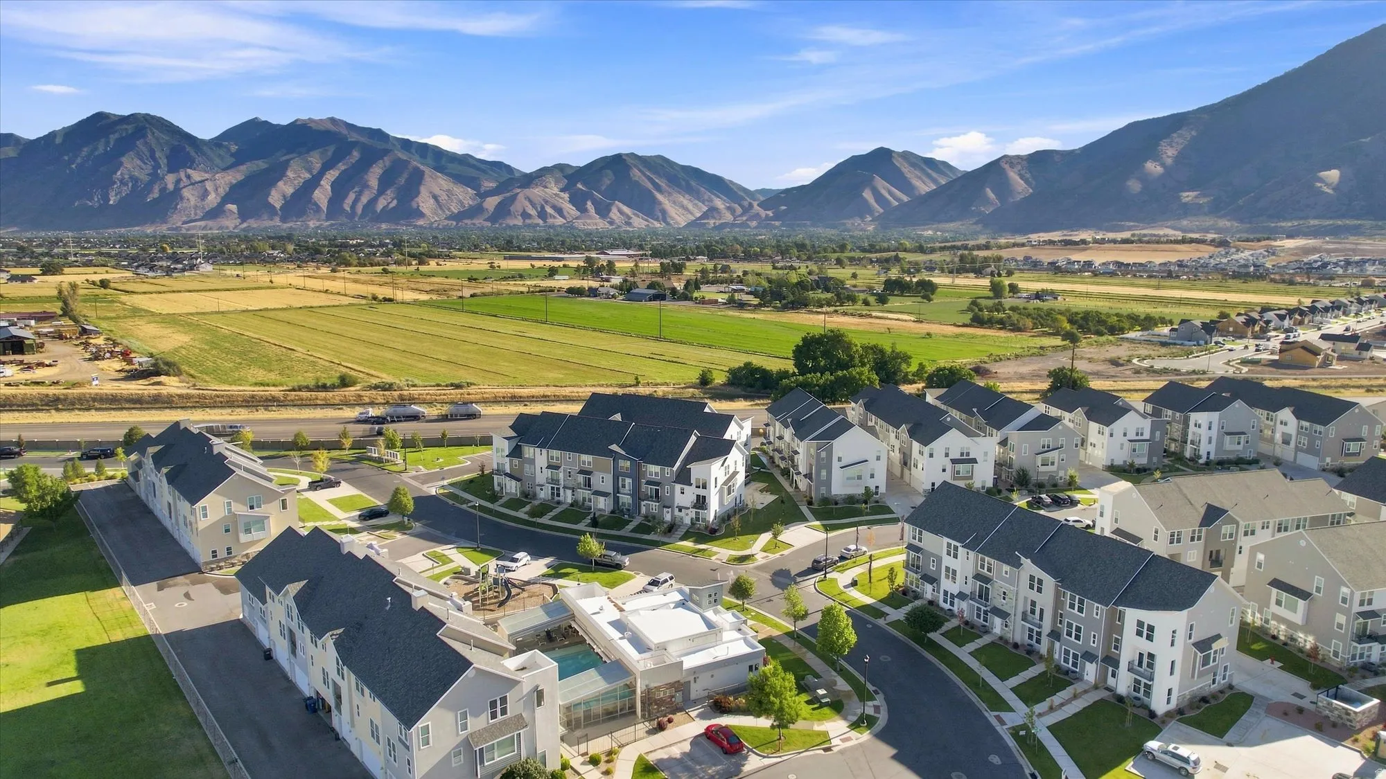 Newly constructed residential development featuring a community pool and prominent mountain backdrop.