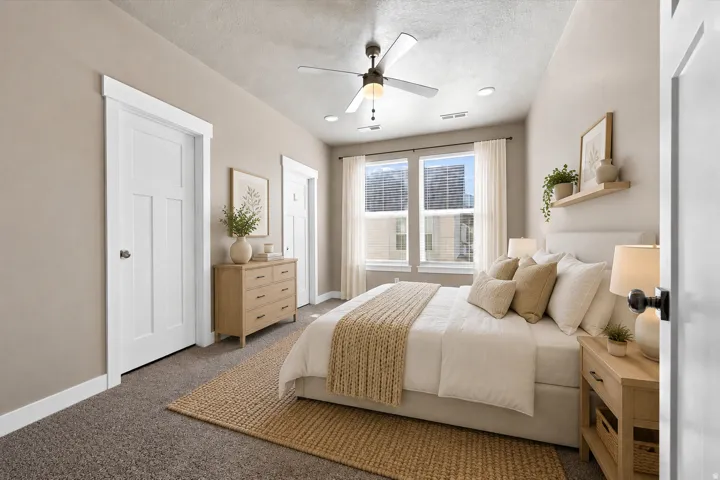 Owners suite carpeted bedroom featuring a walk in closet, ceiling fan, recessed lighting, connecting bathroom, and dual pane windows. (Virtually staged for decor ideas)
