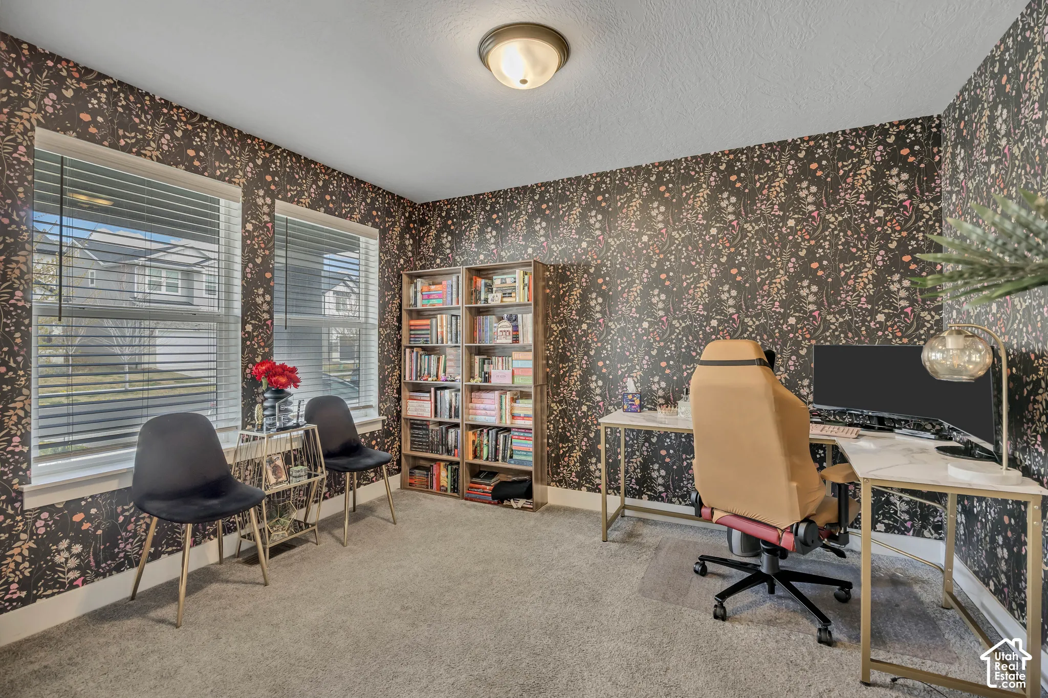 Textured wallpaper, built-in shelving, and two windows with blinds