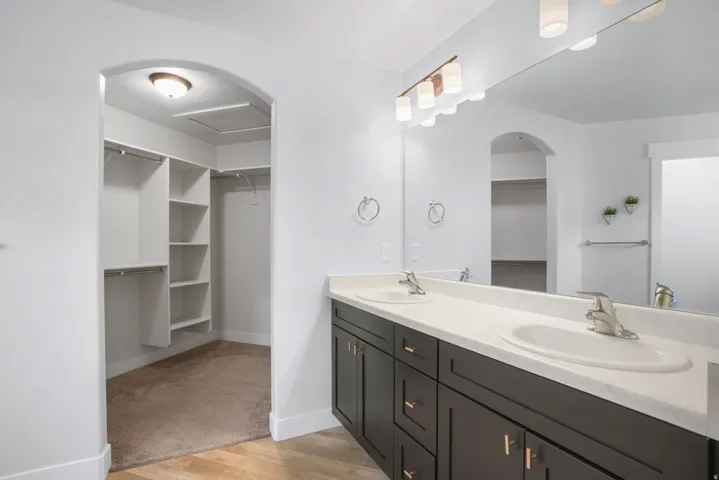 Dual vanity with light-colored countertop, dark wood-finish cabinetry, and brushed nickel fixtures