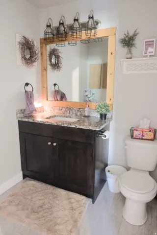 Dark wood-finish vanity with a granite countertop and integrated sink