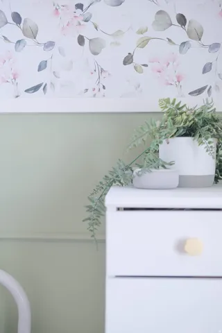 Floral wallpaper accent with a painted lower wall and decorative trim