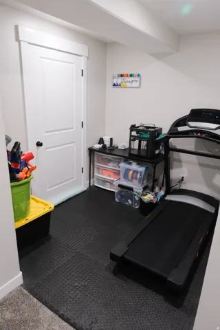 White interior door with dark hardware, recessed lighting, and a neutral wall color