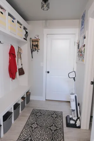 Built-in bench seating with cubby storage, upper shelving, and wall-mounted hooks