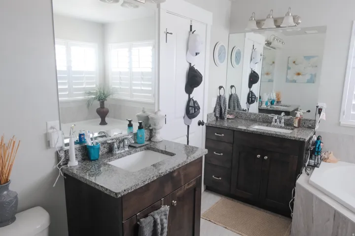 Dual vanities with undermount sinks, granite countertops, and dark wood cabinetry