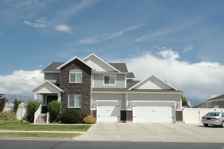 Two-story residence featuring a partial stone facade, covered porch entry, and a two-car garage
