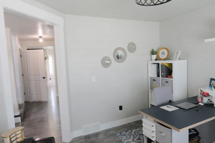 Wood-finish flooring throughout, white interior doors, and a decorative ceiling fixture