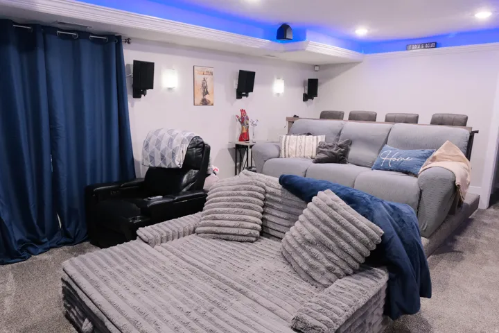 Ceiling-mounted speakers, recessed lighting, crown molding, and wall sconces