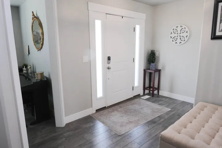 Entryway featuring a white door with frosted sidelights, wood-finish flooring, and light-toned wall paint