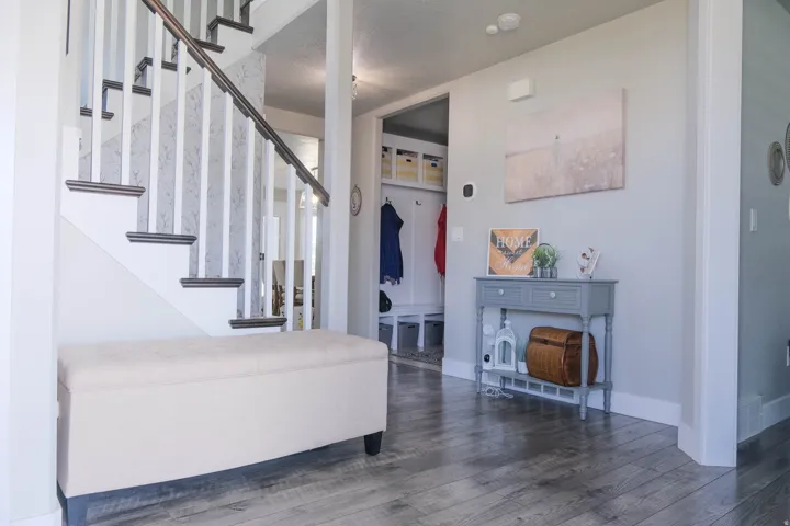 Wood-finish flooring throughout, with a painted staircase featuring dark wood treads and white risers