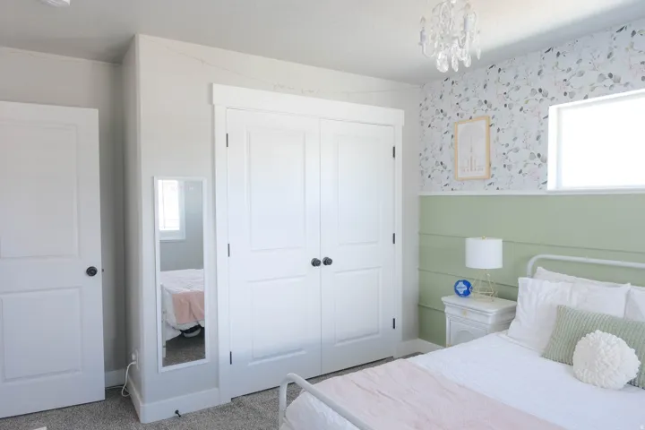 Recessed window, permanent wall treatment, built-in closet with double doors, overhead chandelier