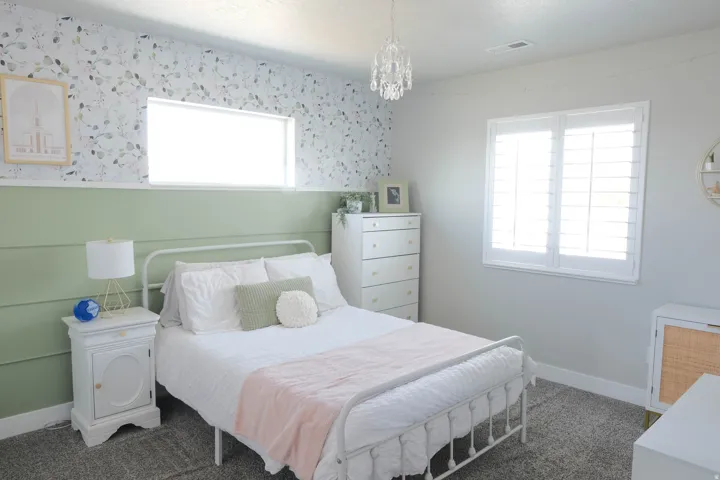 Wall-mounted light fixture, decorative wall paneling, window with white blinds, wall-to-wall carpeting