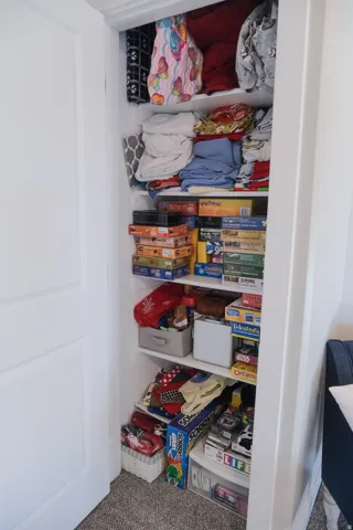 Recessed closet with multiple built-in shelves and a white panel door