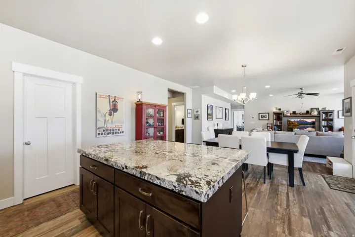 Kitchen island featuring a stone countertop and dark wood cabinetry